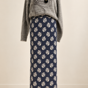 Gonna lunga blu con stampa chiara, abbinata a un maglione grigio sul manichino. Il prezzo si riferisce alla gonna.